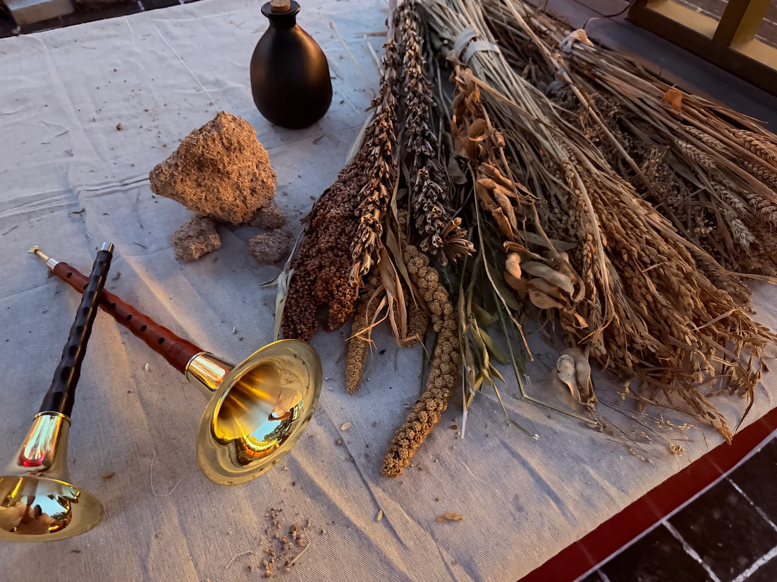 Suona instruments and bundles of grain arranged on the Jining exhibition table.