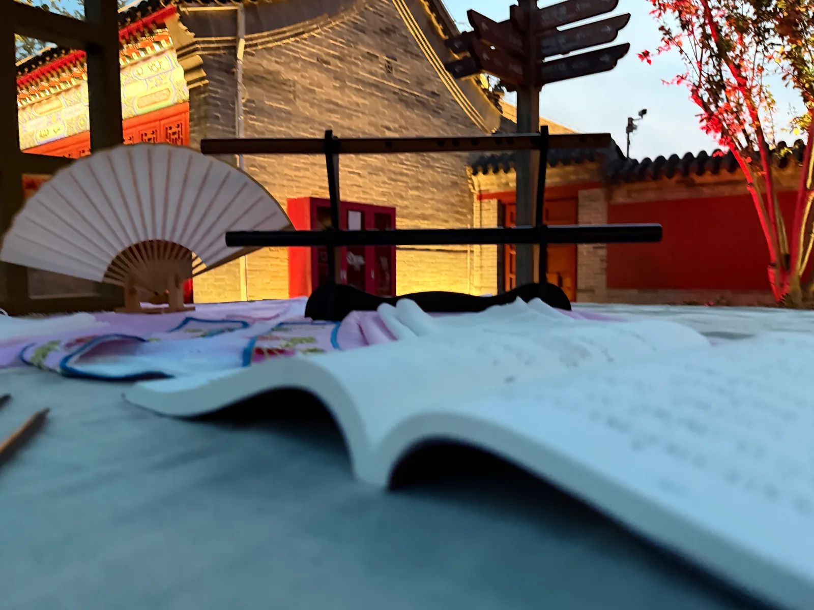 A fan, flutes and an open music book in the evening light.